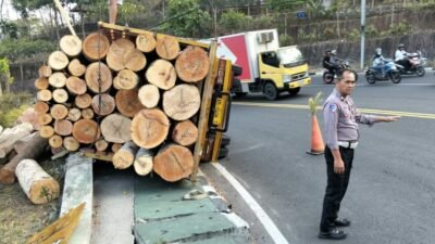 Truk Bermuatan Kayu Gelondongan Terguling di Tikungan Hargodumilah Patuk